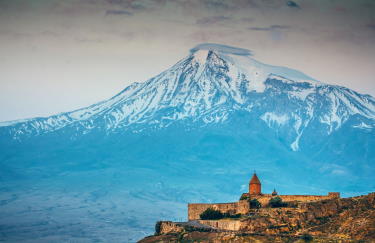 Monastery Khor virap against huge snow capped Ararat Mount in the sunset in Armenia